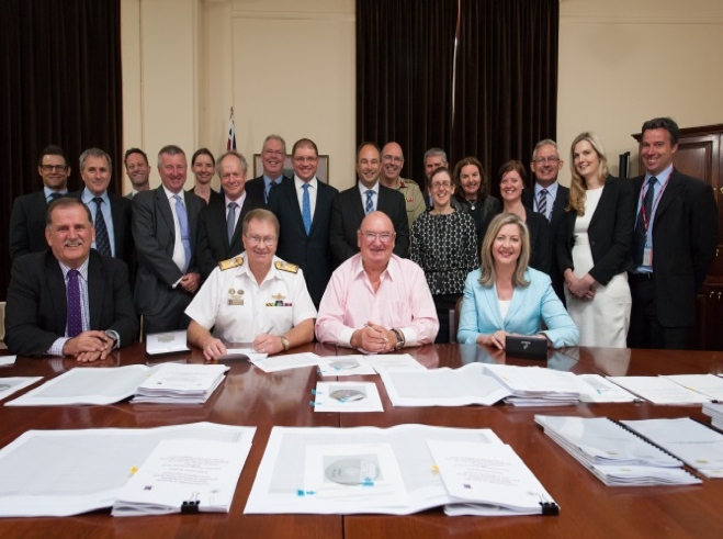 Admiral Thomas and Linfox's Mr Lindsay Fox sign a contract surrounded by team members from the Department of Defence and from industry.